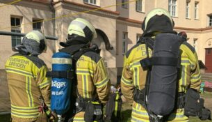 Einsatzkräfte unter Atemschutz stehen bereit. Foto: Feuerwehr Dresden