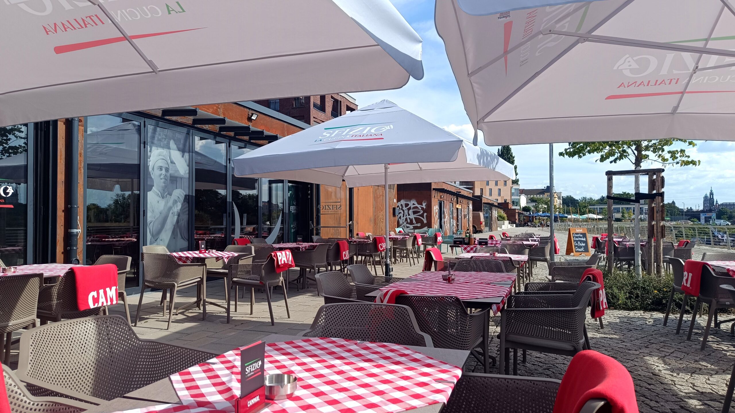 Luftige Atmosphäre im „Sfizio“ am Hafen: Die Glasfassade lässt sich bei gutem Wetter öffnen und sorgt für echtes Open-Air-Feeling.