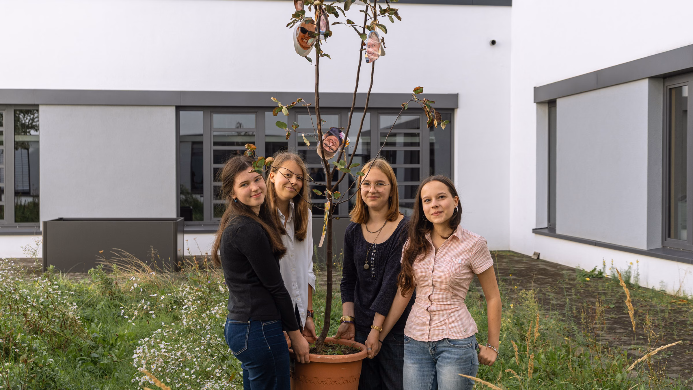 Die vier Schülerinnen aus der zehnten Klasse des Gymnasiums um den Quittenbaum, der bald in dem grünen Innenhof eingepflanzt werden soll. Von links nach rechts: Matilda Sonntag, Smilla Chwalczyk, Merle Rottmann und Marita Hamann. Foto: Sebastian Diehl.